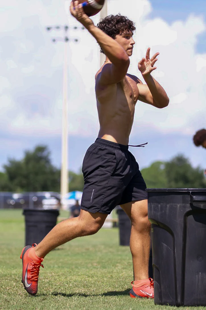 Quarterback throwing during a field session