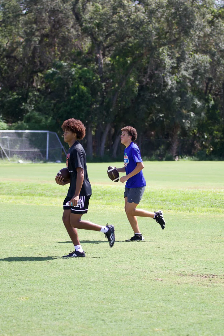 Two quarterbacks working through a drill